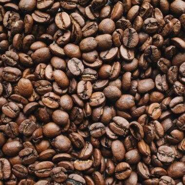 A high-resolution close-up photo of rich, aromatic roasted coffee beans.