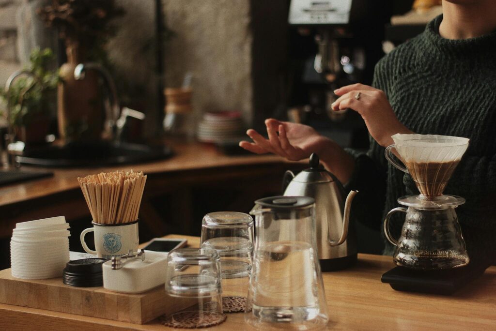 Artisan coffee brewing in a cozy café with a barista using pour-over method.